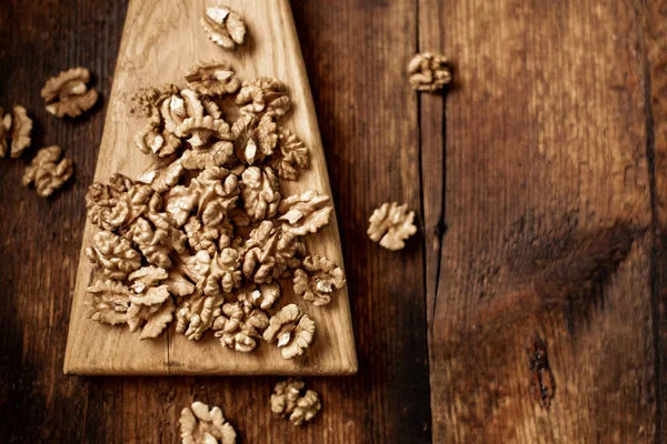 stock image Peeled walnuts. On a wooden background. Healthy food. Natural background.