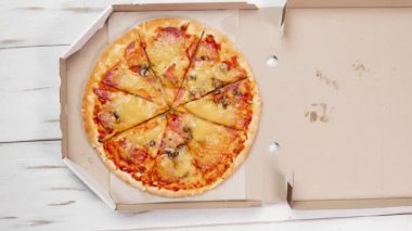 Kutudaki pizza dönüyor. Hareketi durdur. Pizza dilimleri yenir. Fast food.