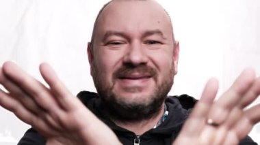 Adam hayır diyor. Beyaz arka plan. Orta yaşlı bir adam, kırk yaşında. Kameraya bakıyor..