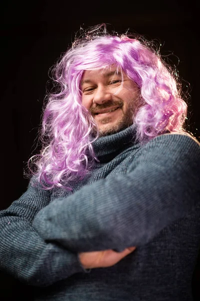 Man Wig Unshaven Man Pink Long Hair Smiles Dark Background — стоковое фото