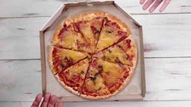 Eller pizzadan bir dilim alır. Karton kutuda pizza. Yemek, atıştırmak..