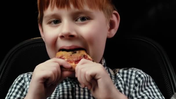 Junge Kaut Pizza Nahaufnahme Dunkler Hintergrund Rothaariger Junge Hunger Appetit — Stockvideo