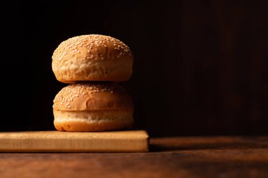 Hamburger çörekleri. Üzerine susam tohumu. Ahşap arka plan. Yemek konsepti. Metin için yer.