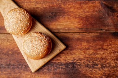 Hamburger çörekleri. Üzerine susam tohumu. Ahşap arka plan. Yemek konsepti. Metin için yer.