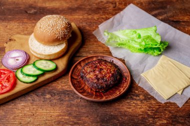 Kızarmış pirzola ve hamburger için farklı malzemeler. Ahşap arka plan. Ev yapımı hamburger..