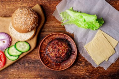 Kızarmış pirzola ve hamburger için farklı malzemeler. Ahşap arka plan. Ev yapımı hamburger..