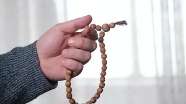 Tespih bir adamın elinde, yakın plan. Dua, meditasyon konsepti.