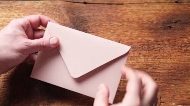 Tanınmayan bir adam kırmızı kalpli bir zarf açar. Aşk mektubu, sevgililer günü konsepti..