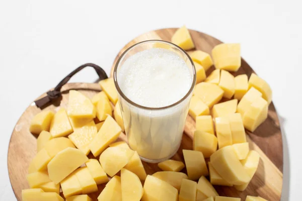 ポテトミルクのコンセプト 代替ミルク 生のジャガイモを刻んだ板の上に牛乳のガラス — ストック写真