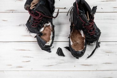 Yırtık ayakkabı çizmeleri. Hafif ahşap zemin. Yırtık, yırtık ayakkabılar.