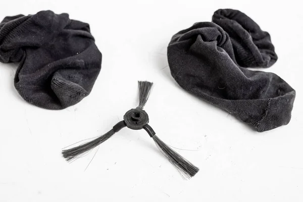 ロボット掃除機から汚れた古い靴下とブラシの詳細 しわのある着用男性の黒の靴下 — ストック写真