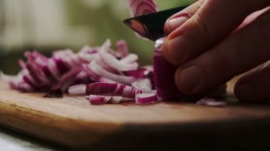 Kırmızı soğan doğra. Tanınmayan bir adam soğan doğruyor. Yemek pişirmek..
