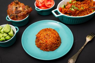 Tabakta jollof pilav. Domatesli pilav, soğan, baharat. Geleneksel Nijerya yemekleri. Koyu arkaplan.