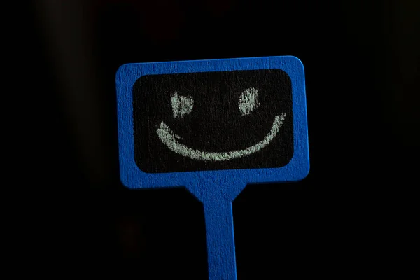 Gülen Suratlı Bir Tabela Siyah Arka Planda Pozitif Bir Gülümsemesi — Stok fotoğraf