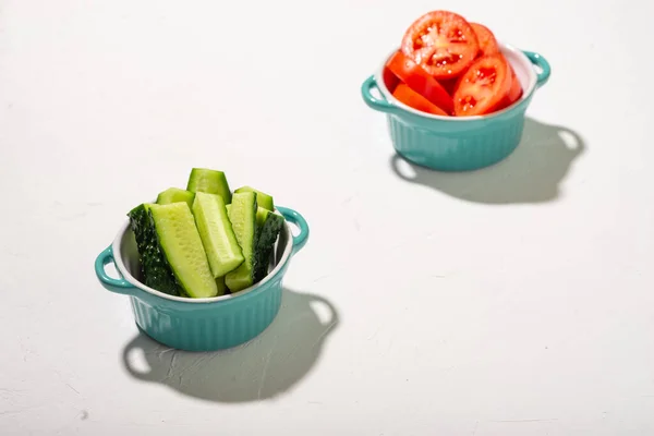 Pepinos Cortados Tomates Xícaras Fundo Branco Legumes Frescos Conceito Vegano — Fotografia de Stock