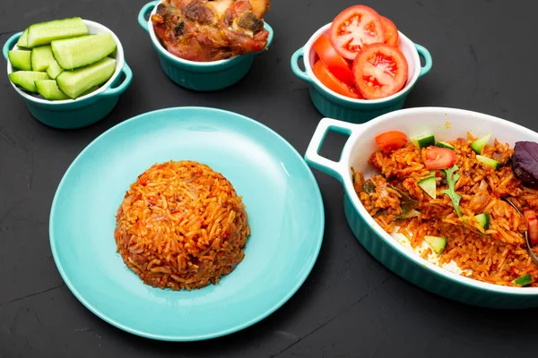Tabakta jollof pilav. Domatesli pilav, soğan, baharat. Geleneksel Nijerya yemekleri. Koyu arkaplan.