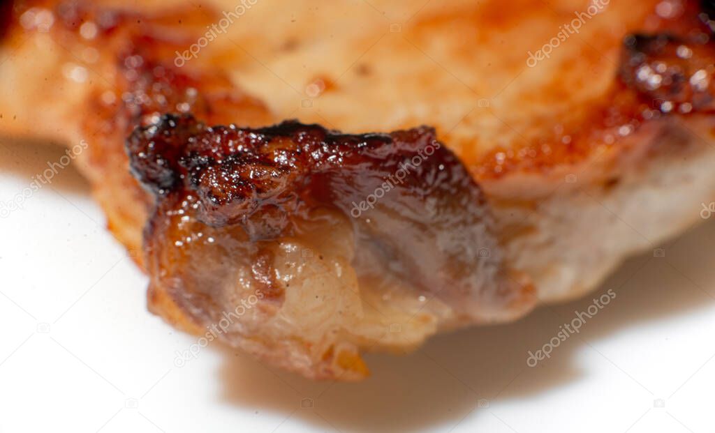 Texture of fried meat close up. A fatty piece of pork at a large approximation. Harm from meat fried in oil.
