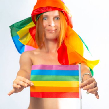 Beyaz arka planda izole edilmiş bayrak taşıyan çekici, orta yaşlı bir kadın. LGBT Uluslararası lezbiyen, eşcinsel, biseksüel ve transseksüel topluluğun sembolü