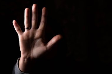 Kadın avuç içi, siyah arka planda kameraya doğrultulmuş. Metnin için yer.