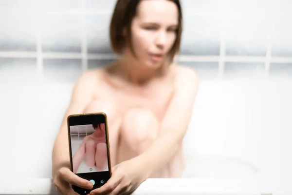 手机在一个自拍的女人手里 裸体自拍 亲密的摄影概念 网上约会 爱情游戏 好女人在浴室里放松 — 图库照片