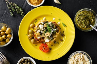 Chimichurri soslu fırında karnabahar bifteği, badem gevreği, sarı tabakta kapari. Vejetaryen yemeği. Alternatif lezzetli yemekler..