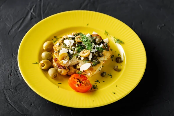 Chimichurri soslu fırında karnabahar bifteği, badem gevreği, sarı tabakta kapari. Vejetaryen yemeği. Alternatif lezzetli yemekler..