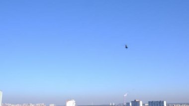 Helikopter şehrin üzerinde uçuyor. Açık hava, mavi gökyüzü.