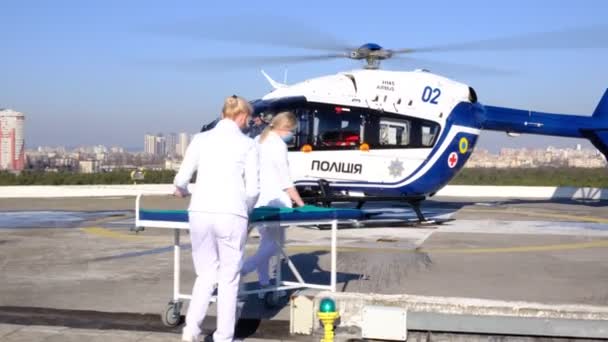 キエフ ウクライナ 2月14 2021 白いコートの医療は ウクライナの警察の救助ヘリコプターに近づき ストレッチャーを運ぶ — ストック動画