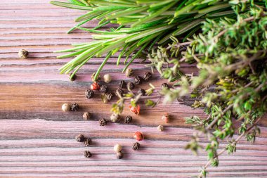 Kekik, biber, mor ahşap arka planda biberiye. Çeşitli baharatlar..