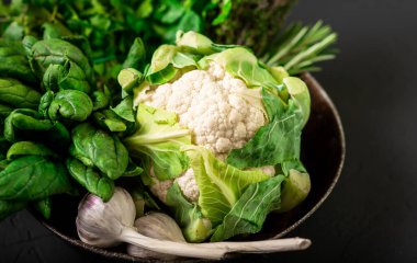 Karnabahar ve çeşitli sebzeler. Sağlıklı, vejetaryen yiyecekler. Koyu arkaplan.