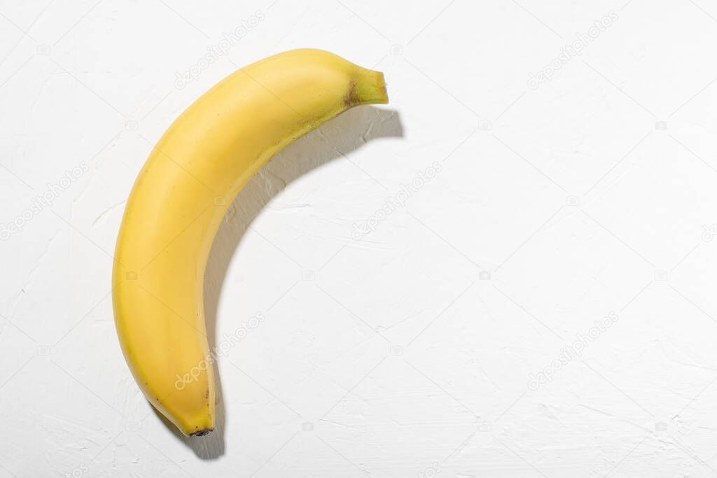 Banana on a white background. Whole unpeeled natural banana.