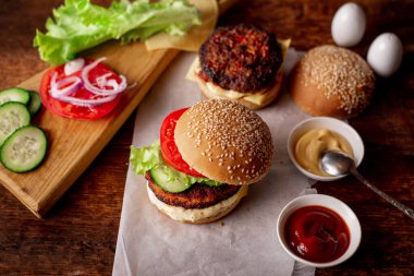 Hamburger ve çizburger için malzemeler. Ahşap arka plan. Ev yapımı hamburger. Yemek konsepti. Hamburger günü..