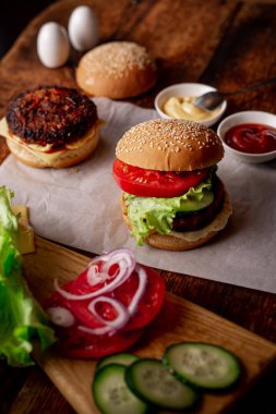 Hamburger ve çizburger için malzemeler. Ahşap arka plan. Ev yapımı hamburger. Yemek konsepti. Hamburger günü..