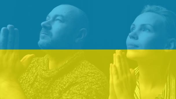 一个男人和一个女人为乌克兰祈祷 乌克兰国旗的背景 乌克兰战争 和平的希望 — 图库视频影像