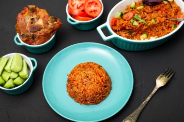 Tabakta jollof pilav. Domatesli pilav, soğan, baharat. Geleneksel Nijerya yemekleri. Koyu arkaplan.
