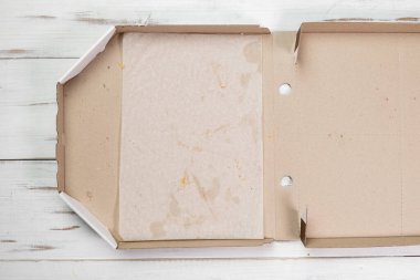 Boş pizza kutusu. Beyaz ahşap arka plan. Pizza yemiş. Üst görünüm.