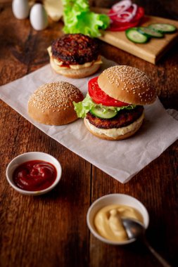 Hamburger ve çizburger için malzemeler. Ahşap arka plan. Ev yapımı hamburger. Yemek konsepti. Hamburger günü..