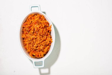 Beyaz arka planda bir tabakta pilav. Geleneksel Nijerya yemekleri pirinç, domates ve baharatlardan yapılır. Üst görünüm, metin için yer.