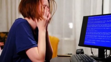 Kadın evdeki mavi bilgisayar ekranının önünde hayal kırıklığına uğradı. Çöküş, bilgisayardaki virüs. Bitkinlik, tükenmişlik konsepti.