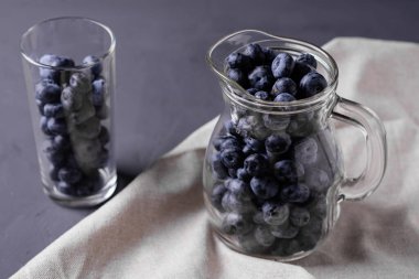 Koyu beton arka planda bir sürahi ve cam yaban mersini. Detoks, smoothie yapımı, böğürtlen hakları konsepti.