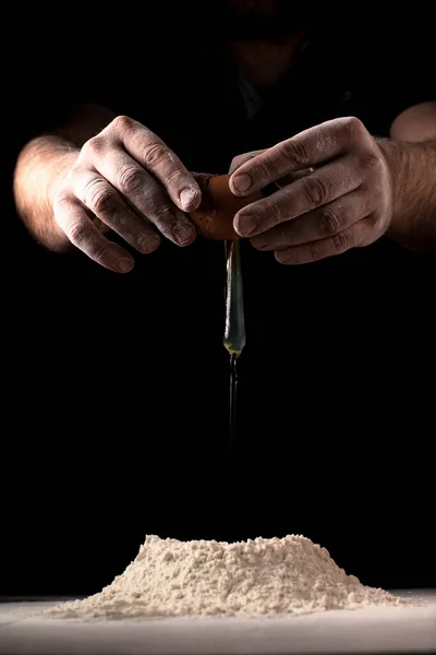 Man Breaks Egg Flour Making Dough Table Dark Background — Stock Photo, Image