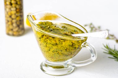 Beyaz arka planda soslu Chimichurri sosu. Arjantin vejetaryen sosu zeytinyağı, kekik, maydanoz.