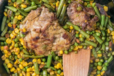 Kavrulmuş sebze ve tavada et..