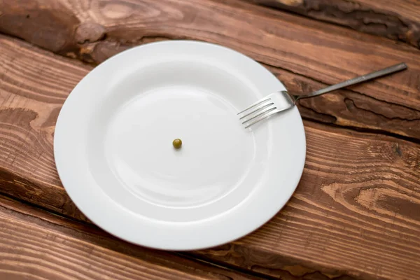 Diétás Fogalom Egy Borsó Egy Fehér Tányéron Táplálkozás Korlátozása — Stock Fotó