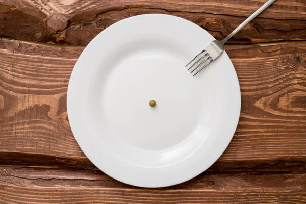 Conceito Dieta Uma Ervilha Deitada Num Prato Branco Restrição Nutrição — Fotografia de Stock