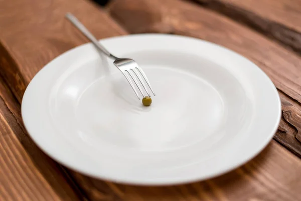 Diétás Fogalom Egy Borsó Egy Fehér Tányéron Táplálkozás Korlátozása — Stock Fotó