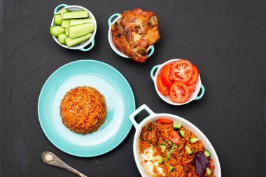 Tabakta jollof pilav. Domatesli pilav, soğan, baharat. Geleneksel Nijerya yemekleri. Koyu arkaplan.