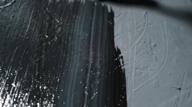 Bir boya fırçası yüzeyi siyah boyayla boyar. Yakın plan. Boyama işini yürütüyorum. Dekorasyon, ev yenileme konsepti.