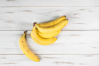 Ahşap bir arka planda bir avuç muz. Benekli sıradan muzlar..
