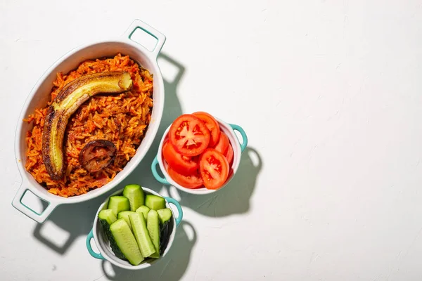 Riz Jollof Banane Frite Légumes Frais Tomate Concombre Fond Blanc — Photo